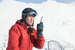 Snowmobiler talking on walkie-talkie